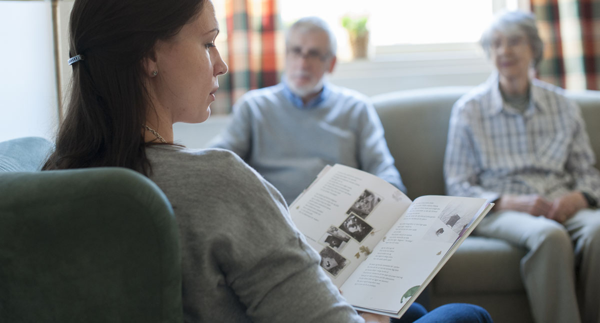 En person läser högt ur en bok bör två äldre personer.